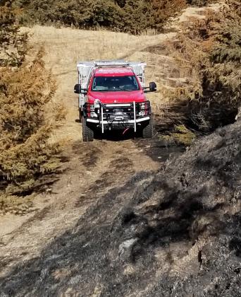 A Phillips firetruck sits at the base of a hill as crews look for hot spots in the Votaw Road Fire last week between North Platte and Welfleet.