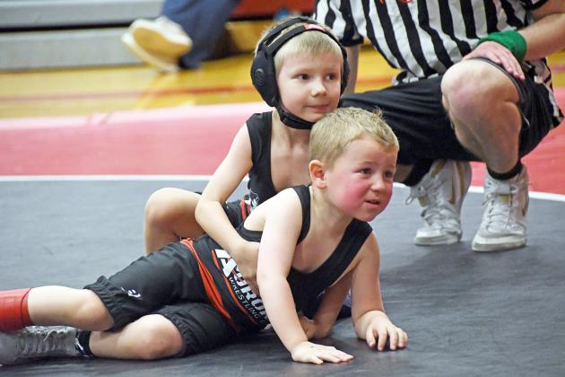 Joseph Sabata and Cannon Dunn look matside for encouragement and instruction during their matchup Friday in Aurora’s youth tournament.