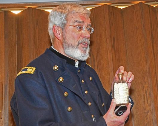 Gary Rath holds up a bottle of opium, a popular painkiller at the time of the Civil War, during his lecture on the era’s medicine. He had many props to show the medical techniques of 1860’s doctors.