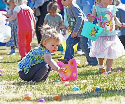 Norah Nickel reaches for an Easter egg as a chaotic group of other 4-to-6-year-olds rush to grab the treats. 