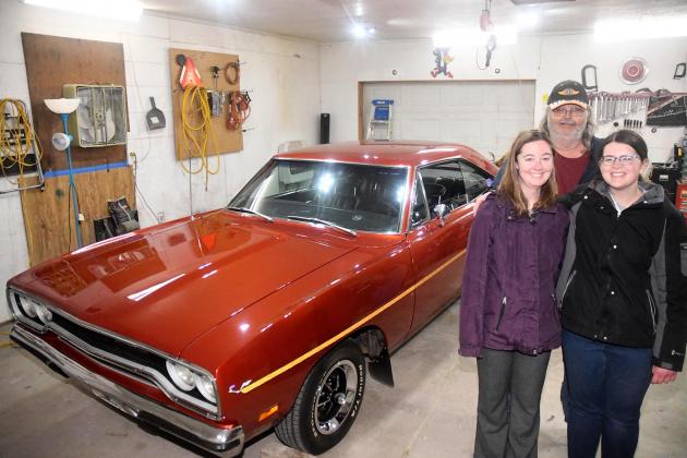 Allan Coats poses with his daughters Tori and Alex in front of the 1970 Plymouth Road Runner in a garage on their property. Most of the renovation occurred in the garage with Alan receiving help from friends and family. 