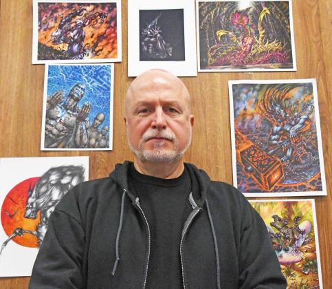Ron Spencer is surrounded by prints of his works at the Alice Farr Library. 