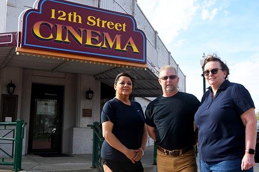 From left: new co-manager Elia Rivera, board president Bruce Hall and co-manager Sheryl Hall stand in front of the 12th Street Cinema. As of May 6 the cinema is showing movies every weekend. Not pictured is new co-manager Monica Lueking.