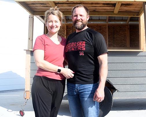 Carrie and Kyle Peterson pose in front of a trailer near their warehouse. The husband and wife partners opened a gardening business on May 5 and will use the trailer to go into town on market days to sell their produce directly to area residents. 