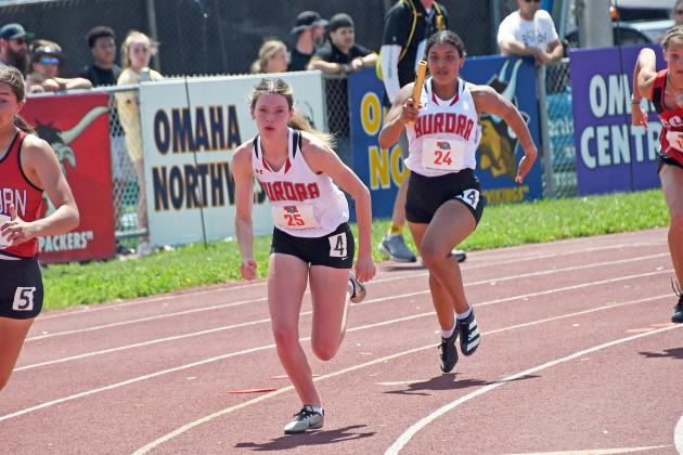 Kehlanee Bengtson (right) delivers the first exhchange to Madelyn Brown during the 400 relay.