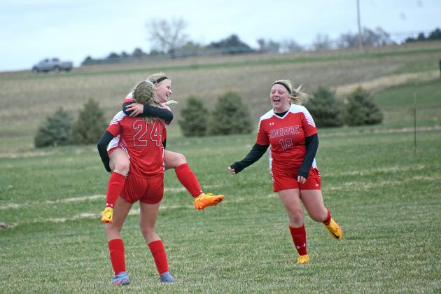 Ellie Hutsell jumps into the celebratory arms of Delaney Nachtigal after scoring her fourth goal of the game in a 5-1 win over York in the B-7 subdistrict tournament Saturday. 