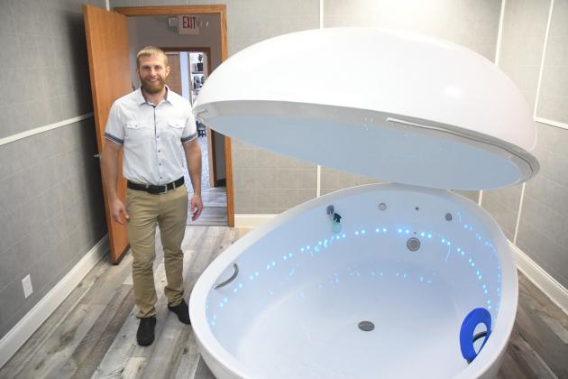 Jerry Lobeda, a 2009 Aurora graduate, stands next to his saltwater flotation device, a sensory depravation tank that is filled by water from an upstairs reservoir, drained and cleaned between each session at Sana Vida Wellness Center in Grand Island.