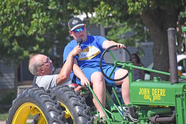 Emcee Deryl Hilligas wandered on to Main Street Sunday to ask young Noah Miller about his ride in the Booster Days parade. Known as “The Voice,” Hilligas interviewed several participants at events throughout the day.
