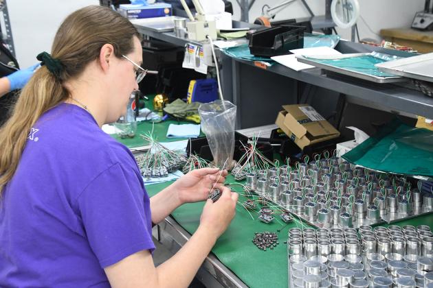 Taylor Lemburg prepares a circuit board assembly for encapsulation at International Sensor System’s plant in the Aurora Industrial Park. Getting parts on time, consistently, has become a supply chain challenge for ISSI and other local manufacturing companies.