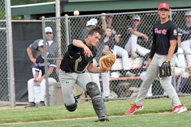 Colin Stolpe fields a bunt and fires down to first base for the out during Aurora Coop Juniors loss to Wood River Thursday. 