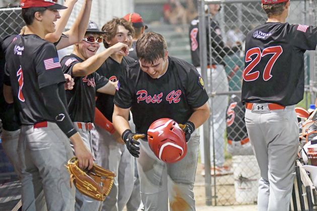 The Aurora dugout celebrates with Dylan Dubas after scoring the tying run in the seventh inning against Wood River. 