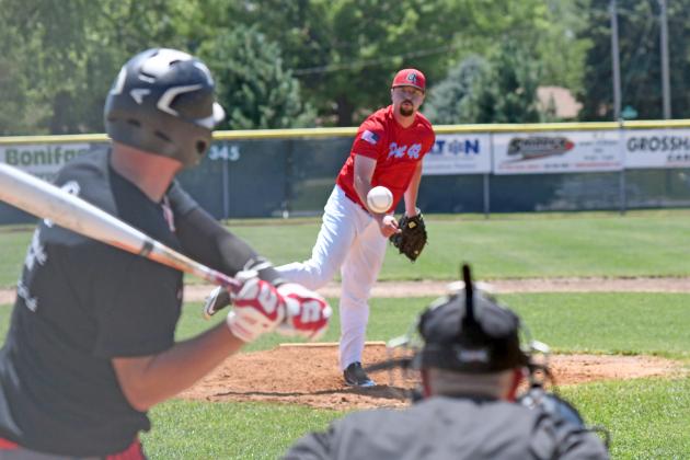 Aurora Post 42 assistant coach Tanner Griffith throws to former player Ben Peard, who played for the alumni squad at Saturday’s friendly contest.