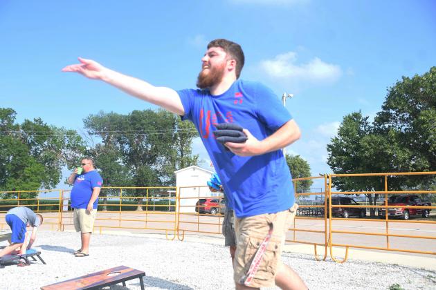 Jeremy Otto tosses a bean bag in the outside cornhole competition during Phillips’ annual July 3 celebration. 