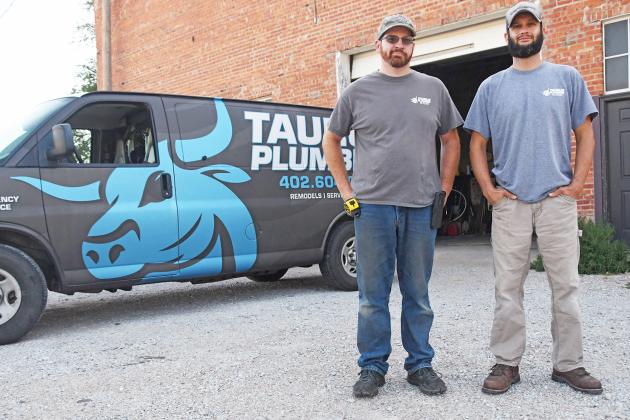 Owner Jeff Munoz (right) and heating and air employee Jason Dieckmann stand by their van for Taurus Plumbing at their office on J Street. 