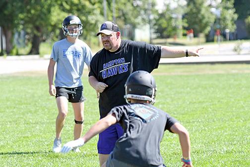 Veteran football coach Jereme Jones, shown here leading the Hawks through preseason workout drills last week, joins the Hampton program after successful stops at St. Edward and Thayer Central. 