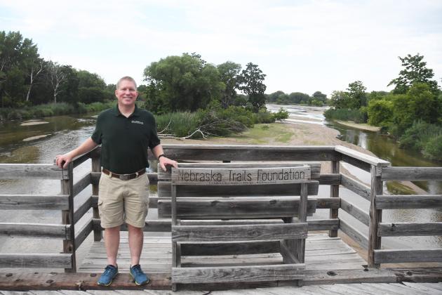 President of the Nebraska Trails Foundation and Dark Island Trails board member Jason Buss pauses for a photo on the mile-long bridge over the Platte River near an island between the banks.