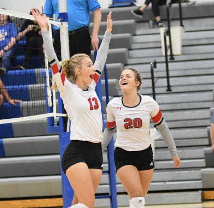 Delaney Nachtigal (left) and Denae Nachtigal celebrate a point during Aurora's loss to Norris Thursday at the Wahoo triangular. 