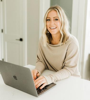 Robyn Johnson at her desk in a promotional photo for her business, Nutrition by Robyn. 
