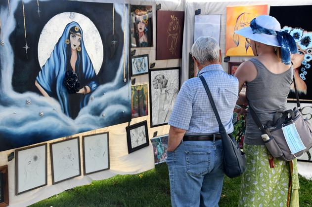 Mother/daughter combo Toddy Rieger from Michigan and Ele Nugent of Grand Island observe some of Alissa Harris’ artwork in a tent at the Aurora Art Walk.