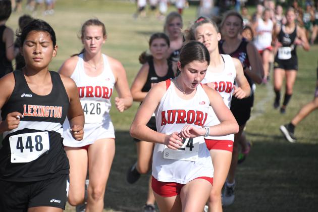 Laighla Rice checks her watch in an early leg of the race while Ayeanna Smith (right) and Ella Curtis (left) keep up the pace.