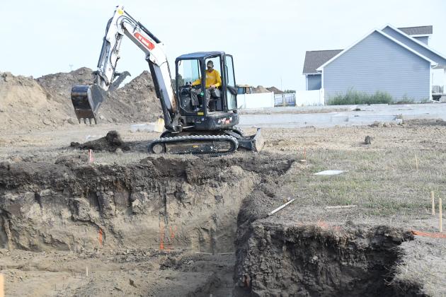 Crews work on a digging a new basement for a single-family dwelling in the Streeter Subdivision Thursday. Two recently poured basements can be seen in the background, represented three of five buidling permits issued for houses last month.
