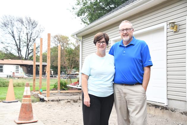 Shelly and Paul Bowman stand in the dug up portion of their driveway on Sept. 14, the day before it was filled in. Also visible is the golf pad that Paul is building to house his golf cart.