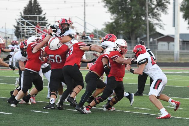 Aurora’s offensive line got the job done Friday against Boone Central, as shown here with a wall of red and black creating a hole for Carlos Collazo (second from right) to slip through for a nice gain.