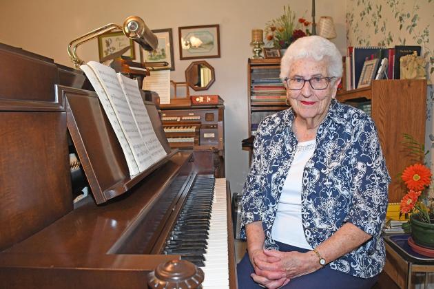 Judy Sullivan poses near her piano, one that was broken in a tornado in 1980, prompting the purchase of another piano until it was fixed. Sullivan has taught hundreds of students music from elementary to private lessons.