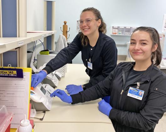 With the CDC community transmission level currently showing as yellow, MCHI’s staff, including clinic lab staff Arianna Harvey (left) and Morgan Sutter, are not required to wear a mask within the facility unless certain circumstances exist or while performing any tests that may normally require them to wear a mask.