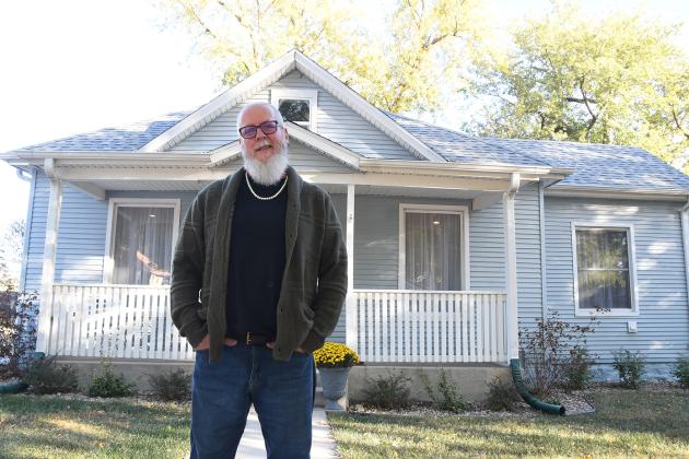 Loren Berthelsen stands outside his Airbnb home on P Street in Aurora. The home for rentals, akin to a bed and breakfast, was purchased for less than $160,000.