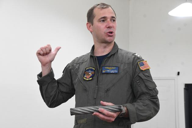 Lt. Brett Mitchell answers a question while holding a piece of wire used to slow down jet fighters as they land on the aircraft carrier. He answered questions about the movie and his career at The Office on Sunday.