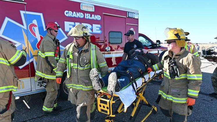Front and center in the action, Giltner Fire Chief Brad Consbruck (left) and firefighter Derreck Eastman help guide this gurney toward an ambulance during the training scenario.