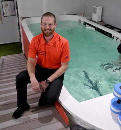 Phil Essliinger sits by the water therapy pool at his new business, Esslinger Physical Therapy, which opened in August on L Street in Aurora.
