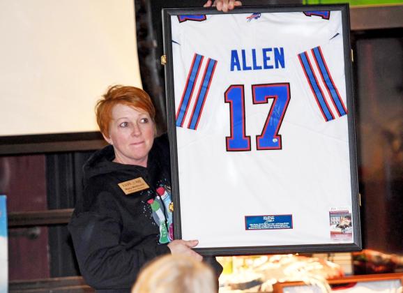 Mary Molliconi holds up a Josh Allen jersey during the live auction Saturday at the Edgerton Explorit Center. The live and silent auction, combined with table sponsorships, raised more than $85,000.