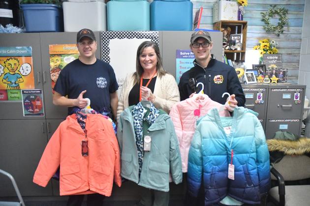 Pictured from left are Tim Graham, elementary guidance counselor Erlinda Amen and Chris Hyde. Graham and Hyde were representing the Aurora Professional Firefighter Association, No. 4956 in making a donation to the school’s annual holiday clothing drive.