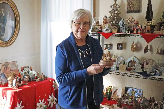 Rural Aurora resident Arlene Gimpel holds the first addition to her now blossoming Nativity scene collection, a music box from her sister. At present, Arlene pays tribute with 136 depictions of the Nativity.