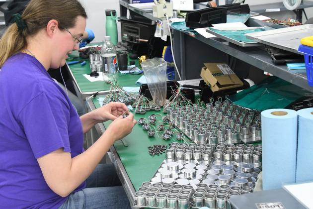 Taylor Lemburg, pictured here in June as part of a report on supply chain economics, prepares a circuit board assembly for encapsulation at the International Sensor Systems plant in the Aurora Industrial Park. ISSI received a $1 million Community Development Block Grant Monday, which will be used to add employees and help the company grow.