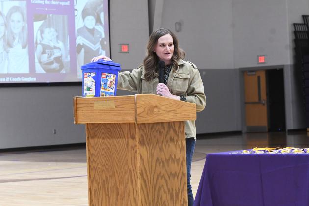 English and journalism teacher Katelyn Goertzen with a Lego bucket and photos of her past on a projector behind her as she gives a speech at Hawk Honors Assembly Dec. 20. Goertzen is a 2006 graduate of Hampton Public Schools and gave a speech of all the “pieces” that built the foundation she has today. 