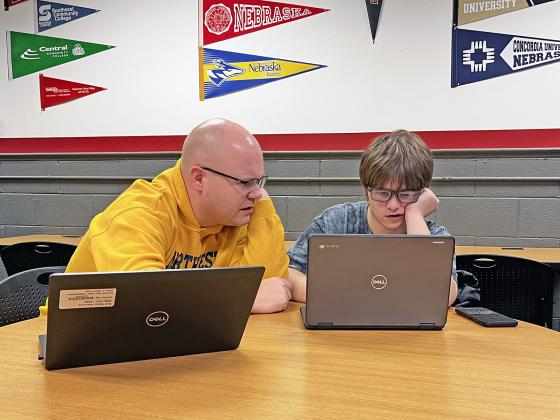 Aurora High School counselor Jake Willems (left) helps senior Husky Vincent DeBord as he fills out a scholarship application during scholarship night Jan. 10.