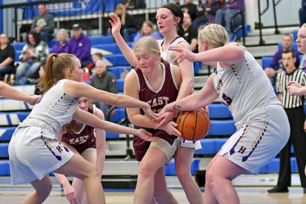 Hampton’s Macy Miller (far left) Neveah Lukassen (behind) and Brooke Lubke (far right) all reach in for a loose ball during a 44-43 win over East Butler in the CRC first round Saturday. 