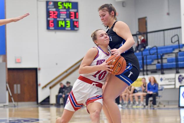 HPC’s Hailey Lindburg dribble drives past an Exeter-Milligan defender during the Storm’s 44-35 win Saturday in the opening round of the CRC tournament in York. 