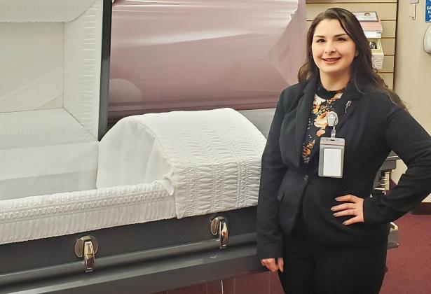 Julia Jones is enjoying learning the ways of Mortuary Science in Ohio. She’s pictured here next to caskets in her school’s display room.