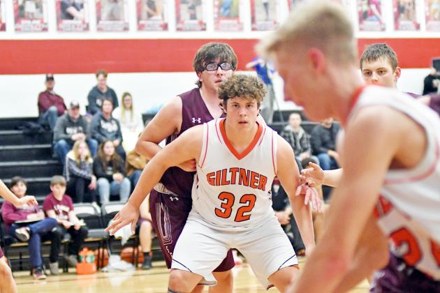 Giltner’s Taylor Smith looks for an opportunity in the paint from his teammate Kale Bish in a 37-33 win over St. Edward Feb. 21. 