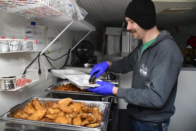 John Boeder and The Leadership Center staff came up with a plan to increase options for eating fish on Fridays during lent. He is shown here with the hot trays, which included pollock, shrimp and baked salmon.