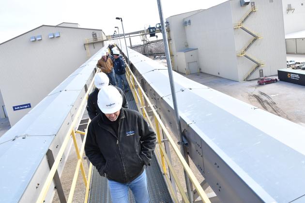 Hamilton County Corngrowers Association members walk across the catwalk between a bulk building and one of the two conditioning towers at the Syngenta Plant outside of Phillips on Thursday. Local growers got to tour the plant seeing the process from truck to warehouse.