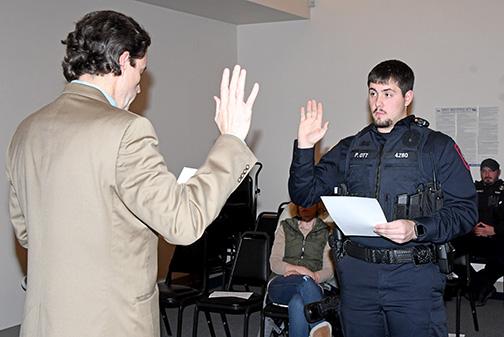 Peyton Ott takes the oath of office last week, beginning his tenure as a member of the Aurora Police Department. Administering the oath is Aurora City Attorney Ross Luzum.