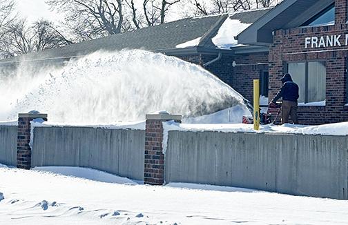 Snowblowers were busy all over town this last week, as business and homeowners, as well as city crews, worked to keep sidewalks and driveways cleared. Crews work here to clear the Aurora Senior Center Sunday afternoon so that it could open up on Monday morning