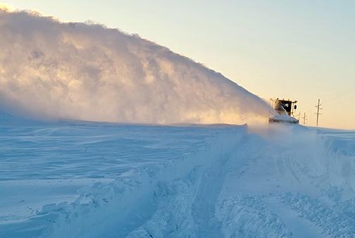 A snowplow equipped with a snow blower throws the white stuff far out into the ditch as it works to clear Highway 4 west of Bruning. (Nebraska DOT photo)