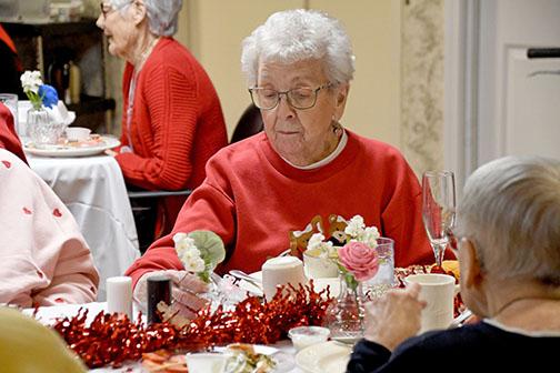 Eileen Chader admires the wooden rose crafted by Nancy Ronnau as part of her Valentine’s Day donation, Roses for Residents. Flowers were gifted to the residents in attendance at East Park Villa’s Valentine’s Day Banquet.