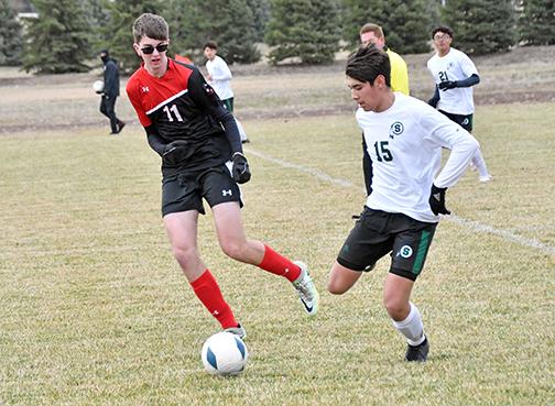 Aurora’s Thomas Brandl tries to slow down the Schuyler offense in the midfield during Thursday’s home opener. 